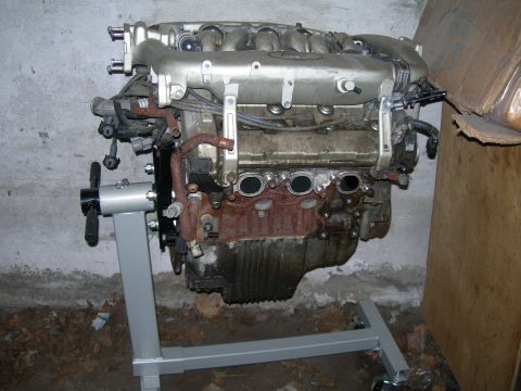 1992 Ford Taurus - A Yamaha-built Ford SHO V6 sits on a gray rolling engine stand in a basement or garage against a bare concrete wall, viewed from the side.…