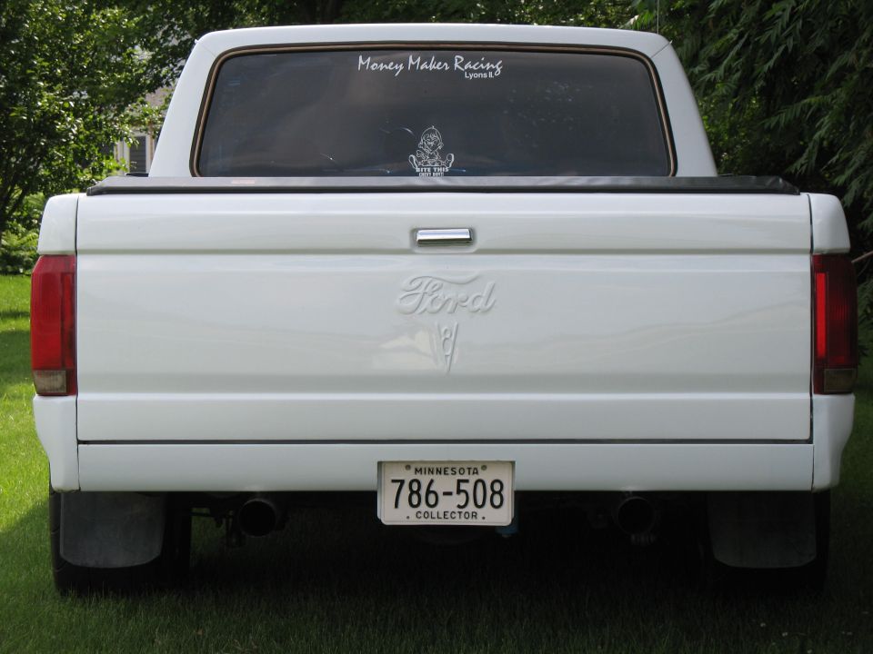 Rear view of white Ford pickup with tonneau cover, dual exhaust, and Minnesota Collector plate 786-508