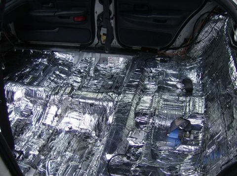 1999 Ford Crown Victoria - Sound deadening material covers the floor and lower door panels of a 1999 Ford Crown Victoria interior.