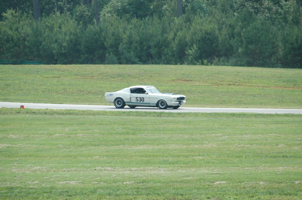 White 1967 Ford Mustang race car with number 530 on the side, driving on a track