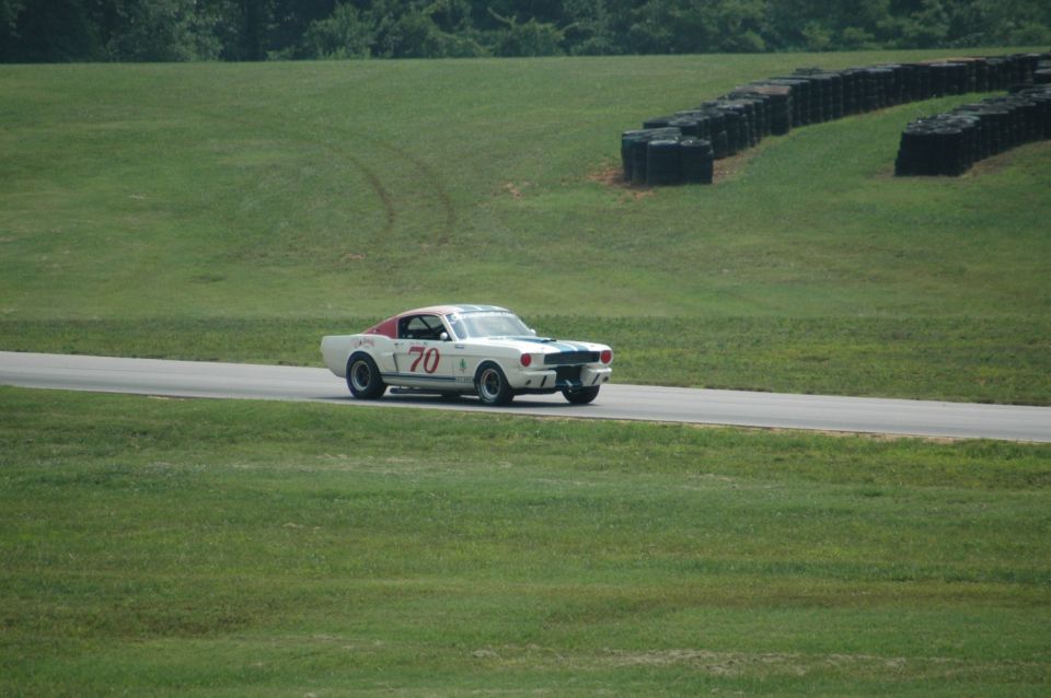 White 1965 Shelby GT350 race car with blue stripes and number 70 on track