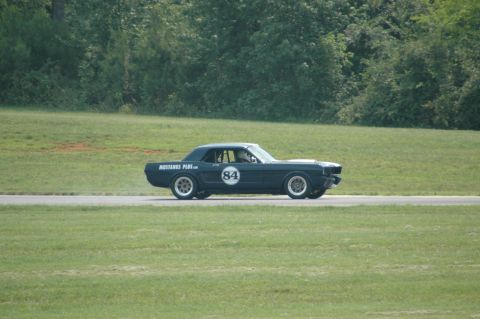 2000 Ford Mustang - Classic coupe with racing number 84 on a track, likely a vintage Mustang.