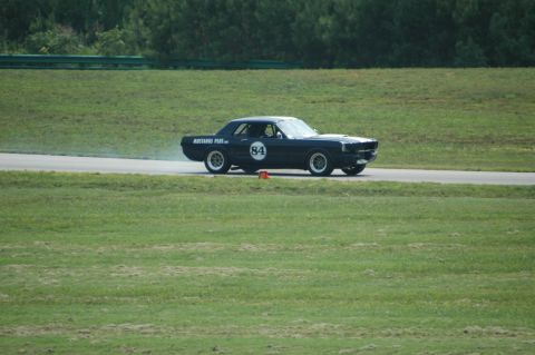 2000 Ford Mustang - A dark blue coupe with racing number 84 is seen on a race track.
