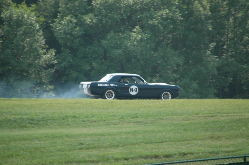 Dark blue 1965 Mustang coupe with racing stripes and number 84 on side