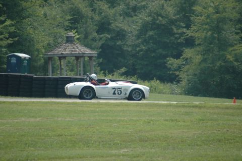 2000 Ford Mustang - A white convertible race car with the number 75 is on a track, with trees and a gazebo visible.