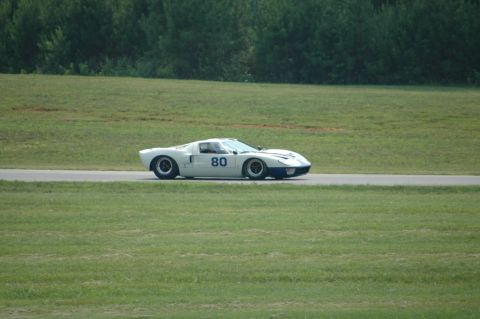 2000 Ford Mustang - A white and blue race car with the number 80 is driving on a track with grassy fields on either side.
