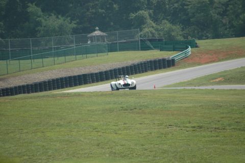 2000 Ford Mustang - A white convertible race car with red and green stripes on the hood navigates a turn on a race track.