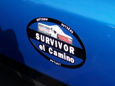 1972 Ford Ranchero - A blue vehicle displays an oval sticker with "SURVIVOR el Camino" and graphics.