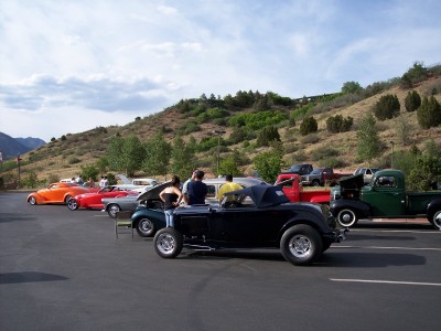1972 Ford Ranchero - A collection of classic vehicles, including a black hot rod and several trucks, are gathered at an outdoor event.