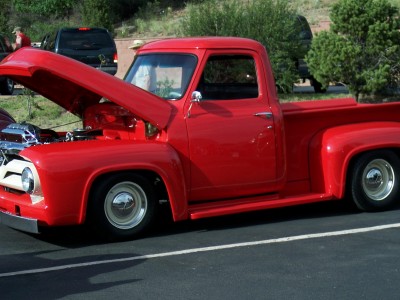 1972 Ford Ranchero - A classic red pickup truck is parked with its hood up, revealing the engine compartment.