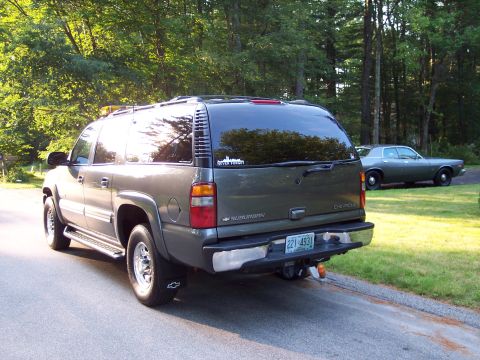 2002 Chevrolet Suburban - This 2002 Chevrolet Suburban is seen from the rear, parked on a road with another car in the background.