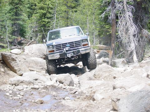 1986 Ford Bronco - This 1980s Ford Bronco navigates a rocky off-road path with large tires and a winch.
