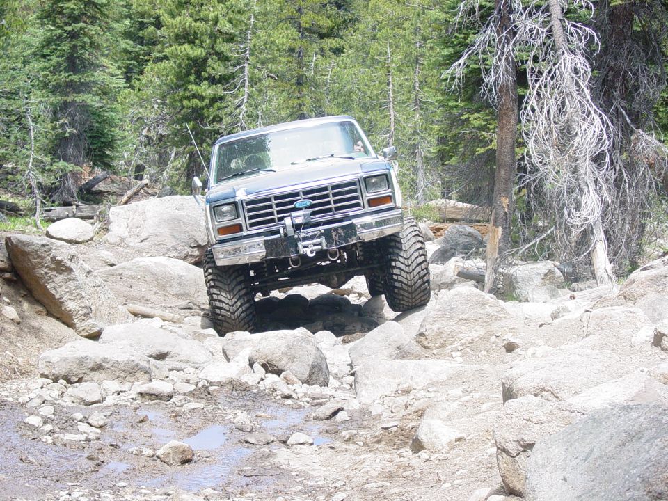 Ford Bronco climbing over rocks on a trail