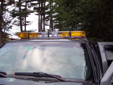 2002 Chevrolet Suburban - Vehicle roof with an emergency light bar, seen from the front windshield.