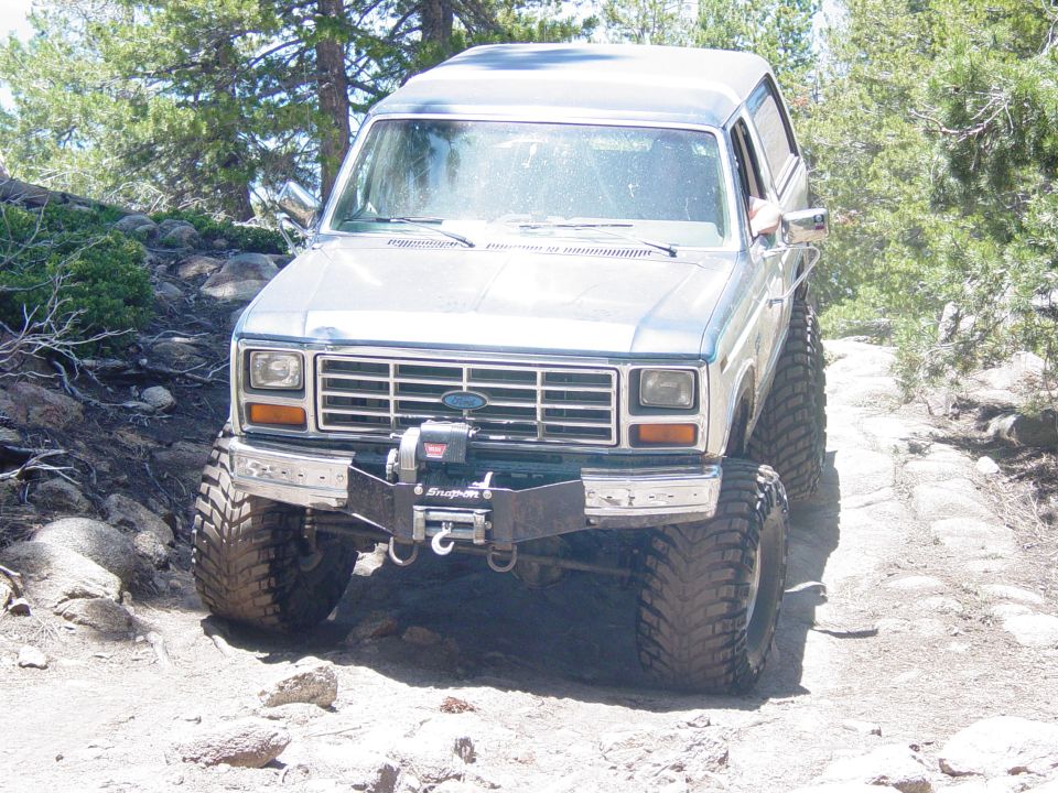 1986 Ford Bronco with winch and aftermarket bumper on rocky trail