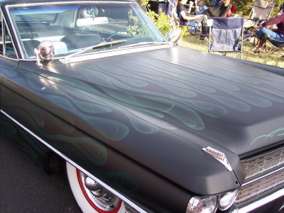1972 Ford Ranchero - A car with custom flame paint is displayed outdoors with people in the background.