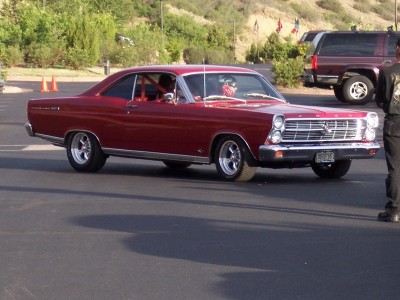 1972 Ford Ranchero - Red 1966 Ford Fairlane coupe parked outdoors, with another vehicle and person visible.