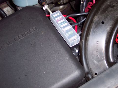 2002 Chevrolet Suburban - A close-up view of a vehicle's fuse box and wiring harness, with some text visible on the fuse box cover.