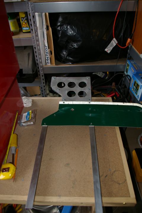 1986 Ford Bronco - Workbench setup with automotive parts, including a metal bracket and a green panel.