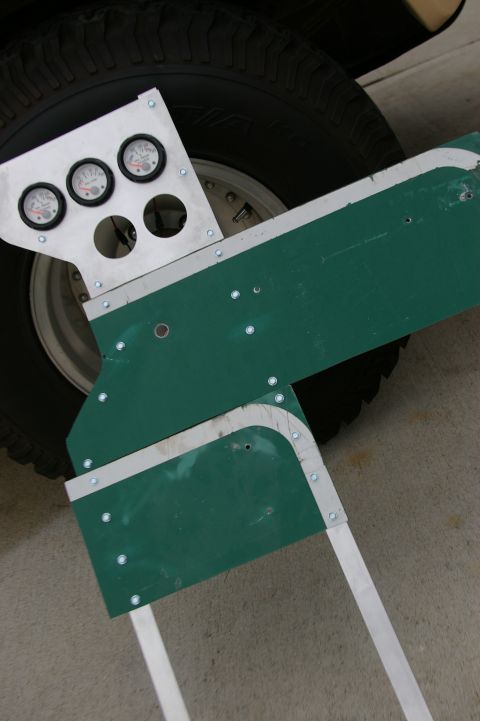 1986 Ford Bronco - Custom gauge panel with three gauges is shown in front of a vehicle's tire and wheel.