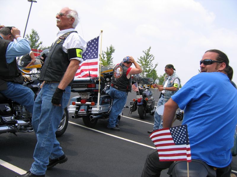 Motorcycles with American flags and people in vests