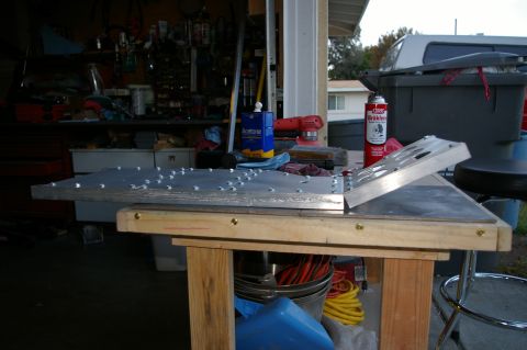 1986 Ford Bronco - A metal console part is being worked on in a garage setting with tools and supplies visible.
