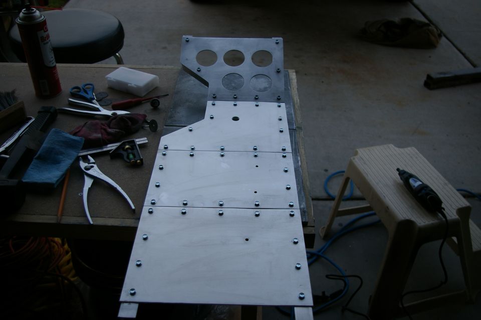 Metal console part with tools on workbench