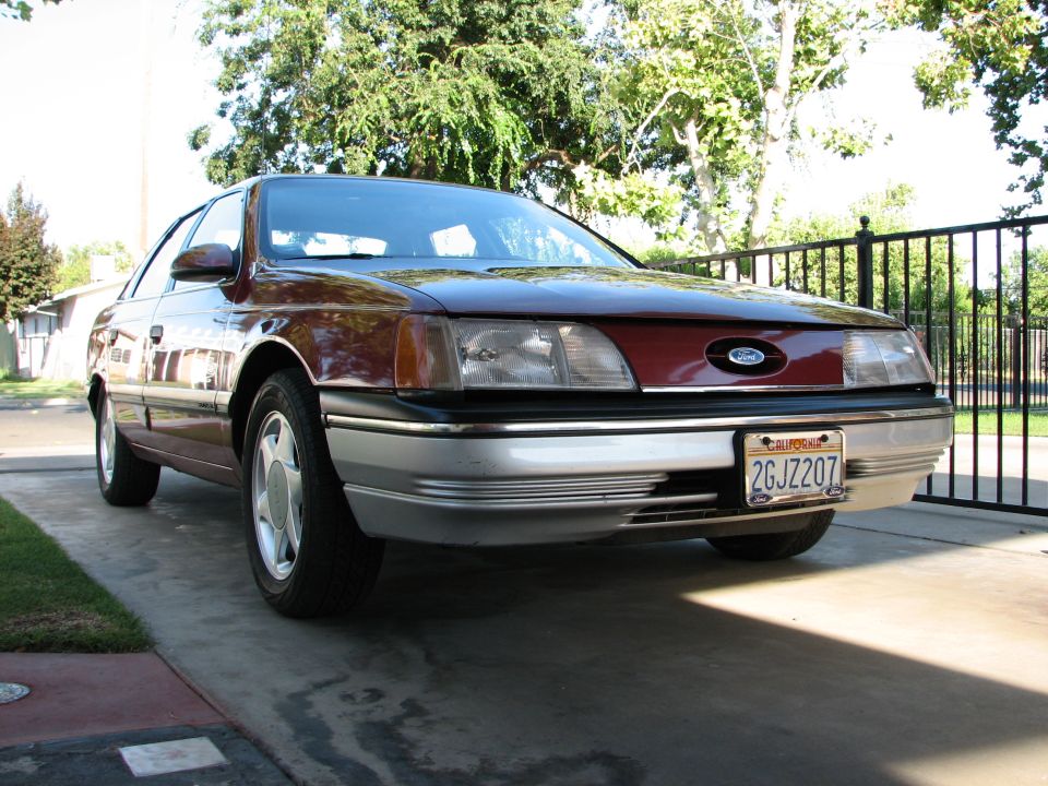 Maroon Ford Taurus with silver lower trim and California license plate 2GJZ207 parked in driveway