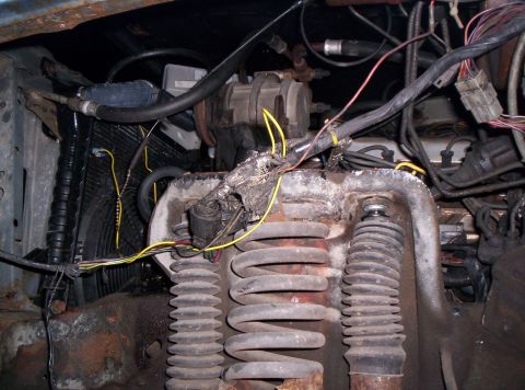 1986 Ford Bronco - Upper Suspension Area. I have removed the plastic wheel wells so I can cut away the nuts that are fused onto the shocks.