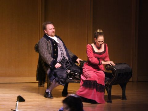 1996 Ford Probe - Two actors in period attire are seated on a bench during a theatrical performance.