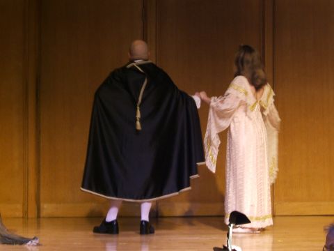 1996 Ford Probe - A man in a black cape and a woman in a white gown stand on a stage, holding hands.