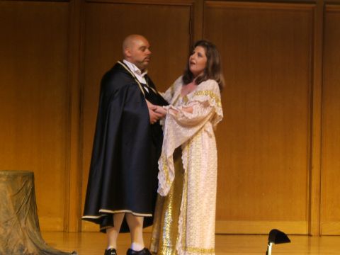 1996 Ford Probe - Two actors perform on stage in elaborate costumes, one wearing a dark cape and the other a shimmering gold-patterned gown.