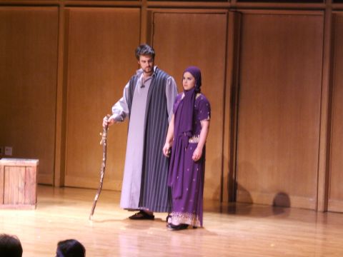 1996 Ford Probe - Two actors in period costumes perform on a wooden stage with a plain backdrop.