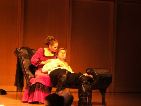 1996 Ford Probe - Two actors in period costumes are on a stage, with one resting on the other's lap.