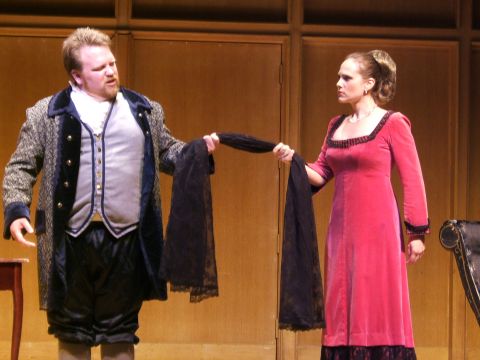 1996 Ford Probe - Two actors on a stage, one in a blue and grey coat and the other in a pink dress, are holding a black scarf between them.
