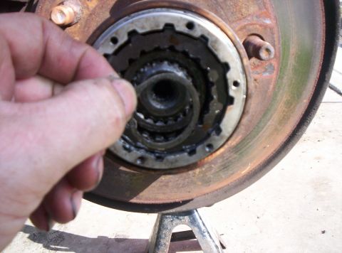 1986 Ford Bronco - Close-up of a vehicle's manual locking hub mechanism being serviced.