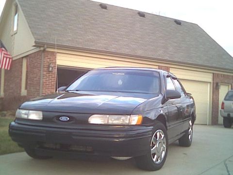 1993 Ford Taurus - A 1993 Ford Taurus is parked in front of a house with a two-car garage.