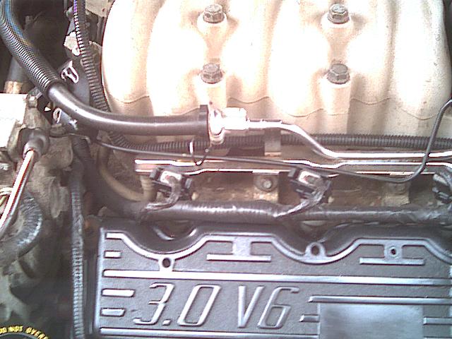 Engine bay with black '3.0 V6' valve cover, fuel rails and wiring