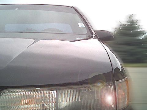 1993 Ford Taurus - Front view of a 1993 Ford Taurus, highlighting its headlight and hood lines.