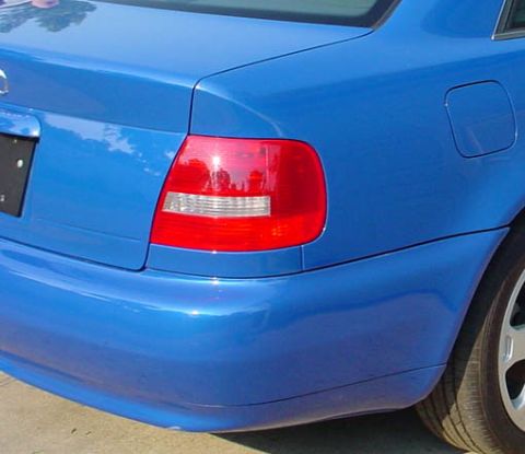 1993 Ford Taurus - Close-up of a blue car's rear section, showing the taillight and a portion of the bumper.