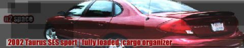1993 Ford Taurus - The rear of a red sedan is shown, with text indicating it is a 2002 Taurus SES sport model.