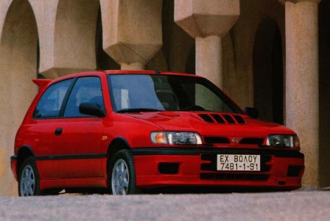 1993 Ford Taurus - This red hatchback features a prominent spoiler and hood vents, with a license plate reading EX ΒΟΛΟΥ 7481-1-91.