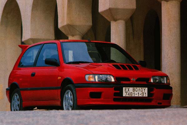 Red three-door sport hatchback, front 3/4 view, with hood vents and Greek plate