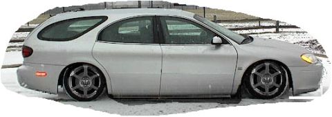 1993 Ford Taurus - This silver station wagon, likely a 1996 model, is shown from the side with aftermarket wheels and a lowered stance.