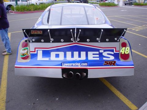 1993 Ford Taurus - A race car with Lowe's sponsorship is viewed from the rear, showing its distinctive livery and dual exhaust.