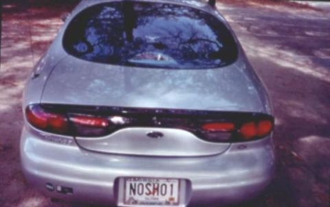 1998 Ford Taurus - Rear view of a 1998 Ford Taurus sedan, showing taillights and license plate.