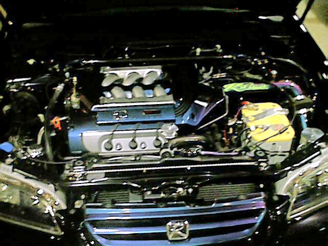 Detailed Honda four-cylinder engine bay with polished intake manifold and Honda H grille emblem