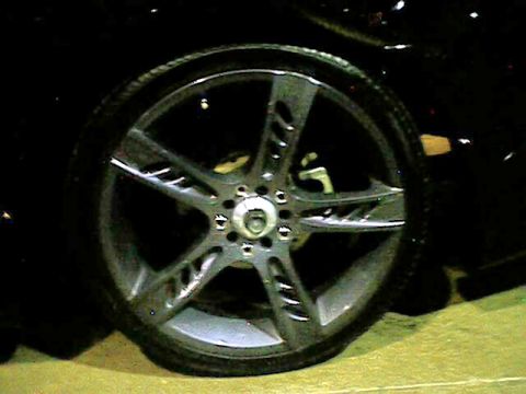 1998 Ford Taurus - A close-up view of a custom five-spoke wheel on a black vehicle, with "SUPERMOTORS" visible at the bottom right.