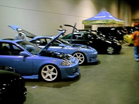 1998 Ford Taurus - Cars on display at a car show, with multiple vehicles visible and hoods open.