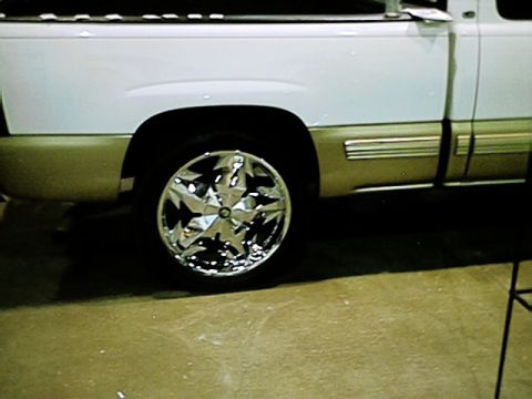 1998 Ford Taurus - Close-up of a pickup truck's side with custom chrome wheels and a two-tone paint job.